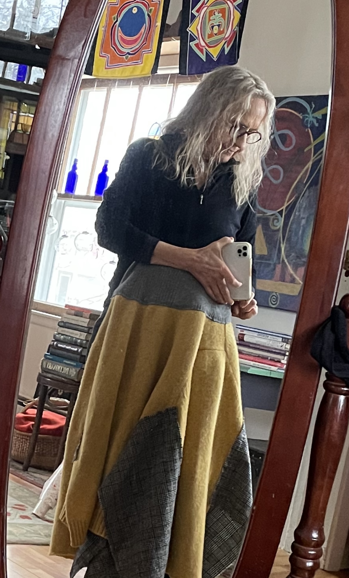 a woman taking her photo in a mirror, trying on a custom dress that she designed